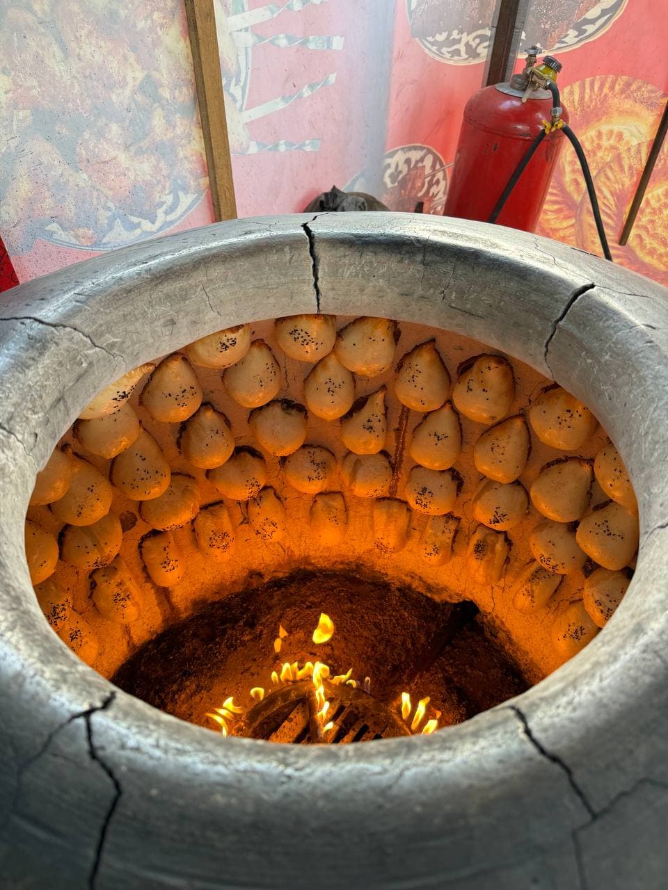 Somsa baking on the inner wall of a tandoor