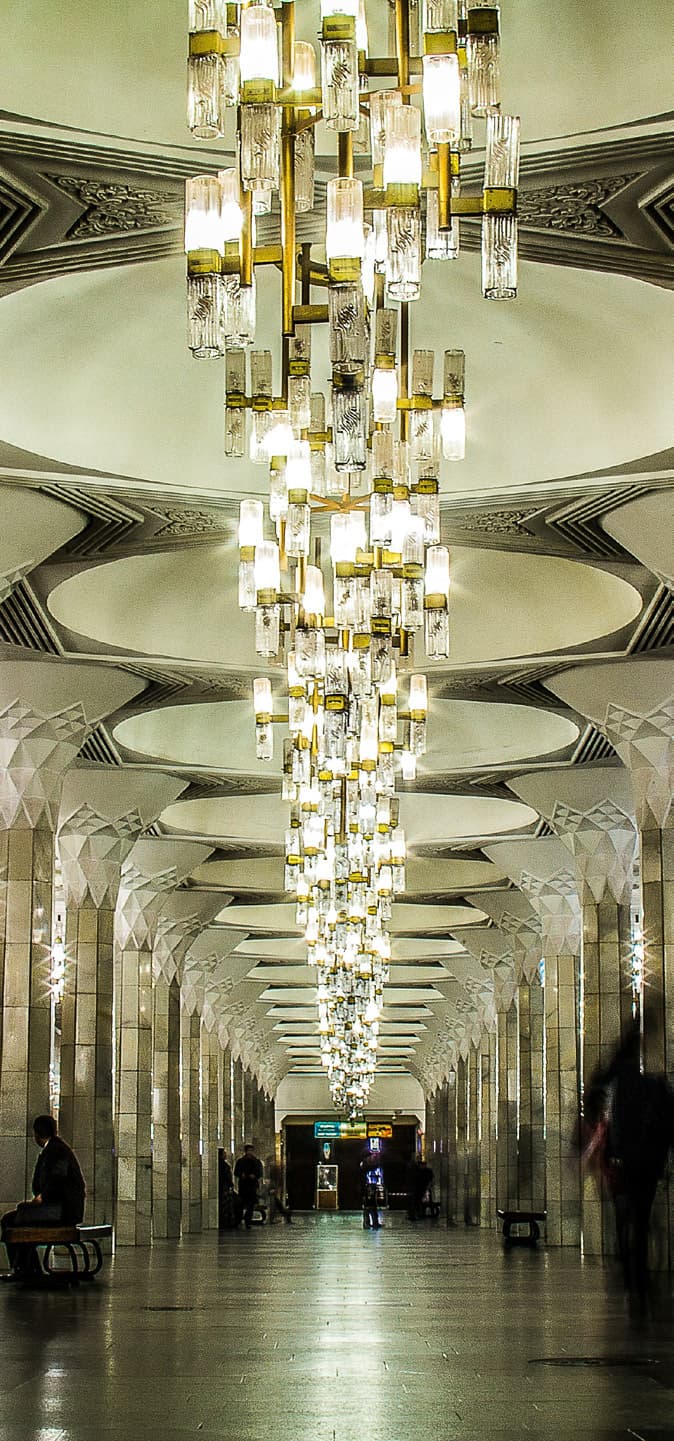 A Tashkent Metro station: a row of crystal chandeliers under a vaulted ceiling, with columns along the platform