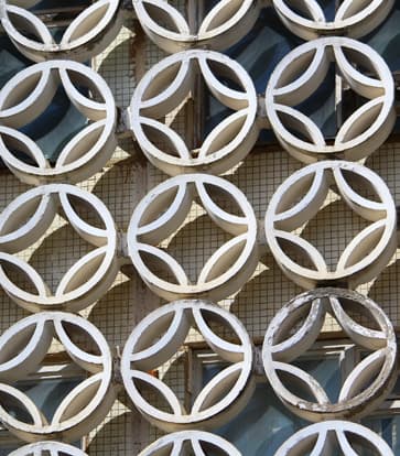 Close-up of a concrete pandjara lattice with repeating white circular elements