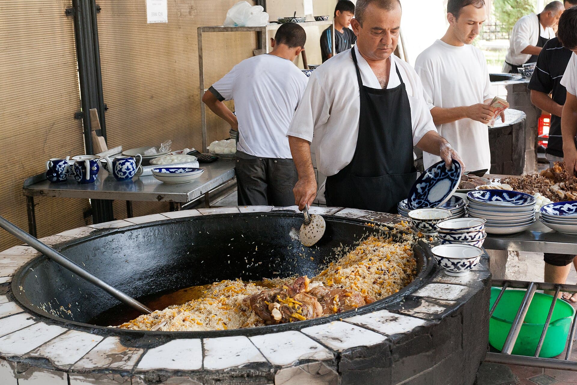 A cook spreads rice over a kazan of plov in Tashkent