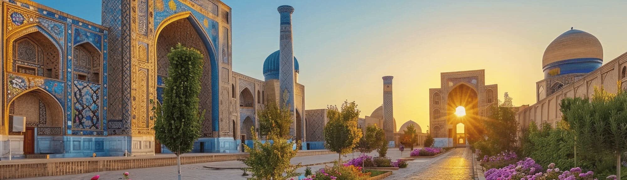 Madrasas with blue tilework and turquoise domes in Samarkand at sunset, with a minaret, trees and flowerbeds in the foreground