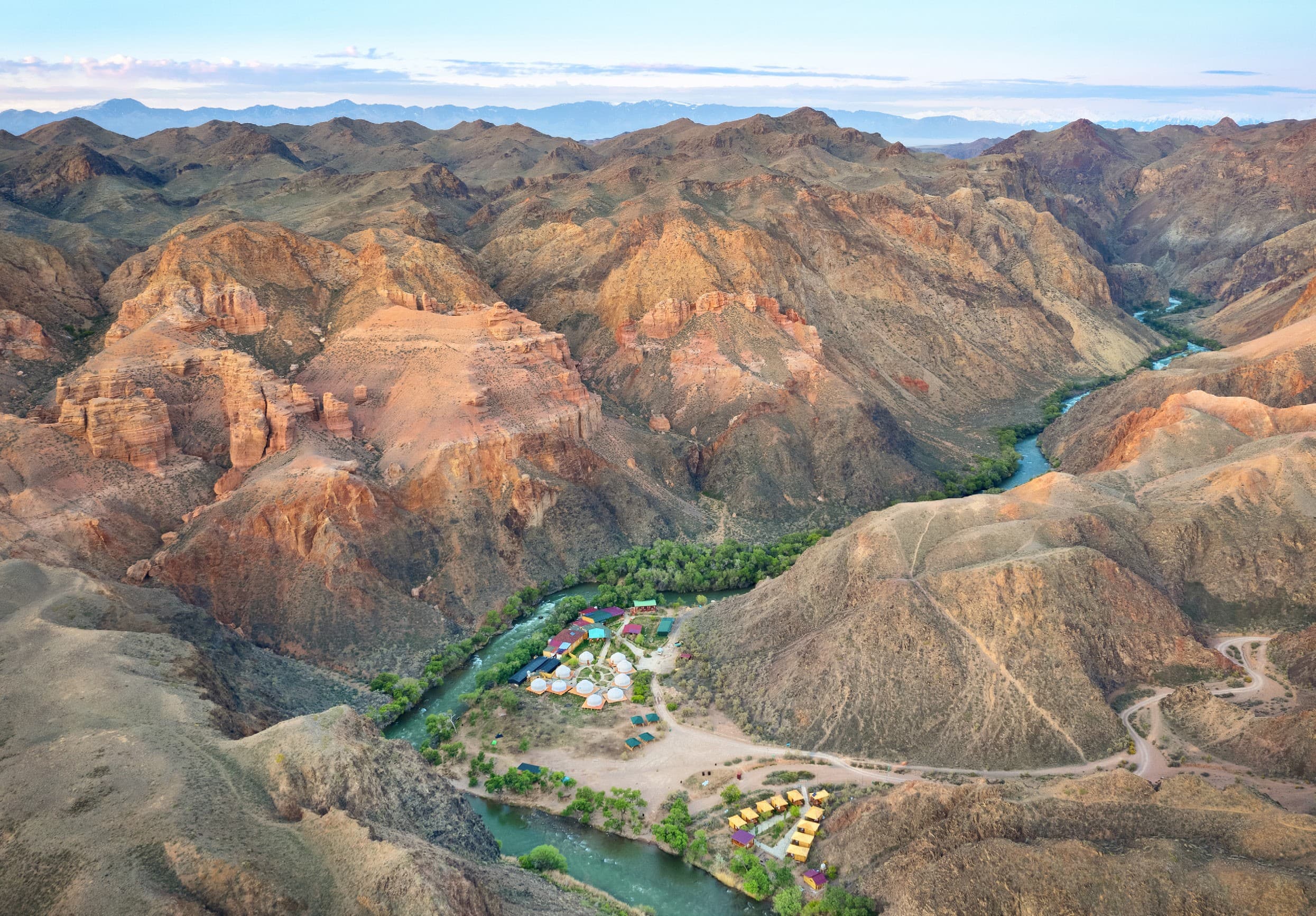 Charyn Canyon: red and ochre ridges, the river at the bottom of the gorge and a camp on its bank