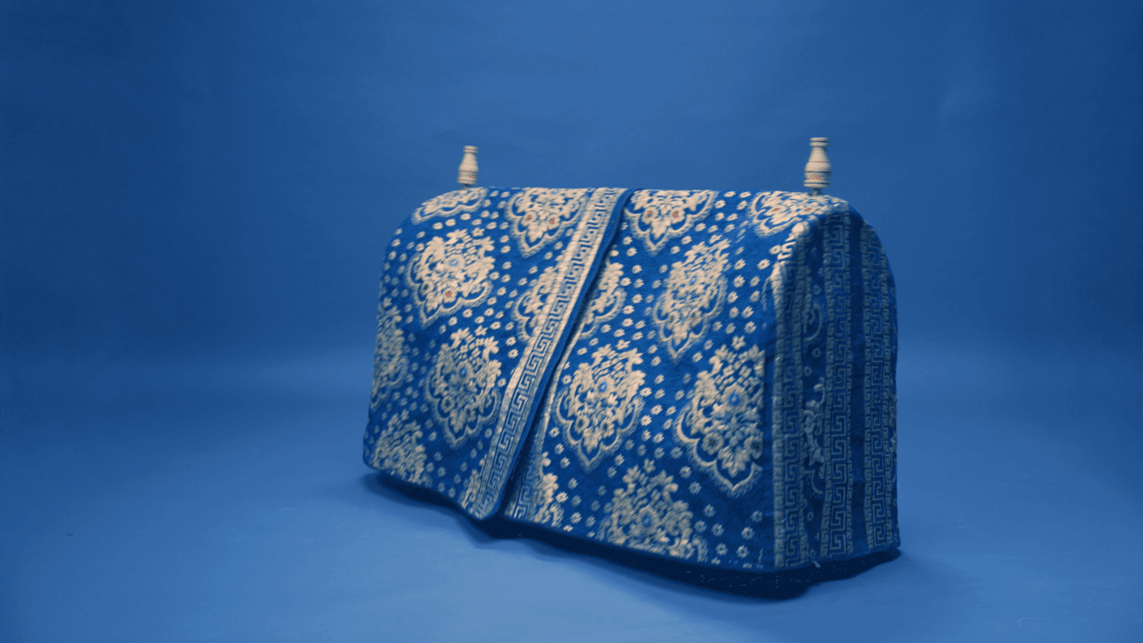 A carved wooden beshik cradle with bedding